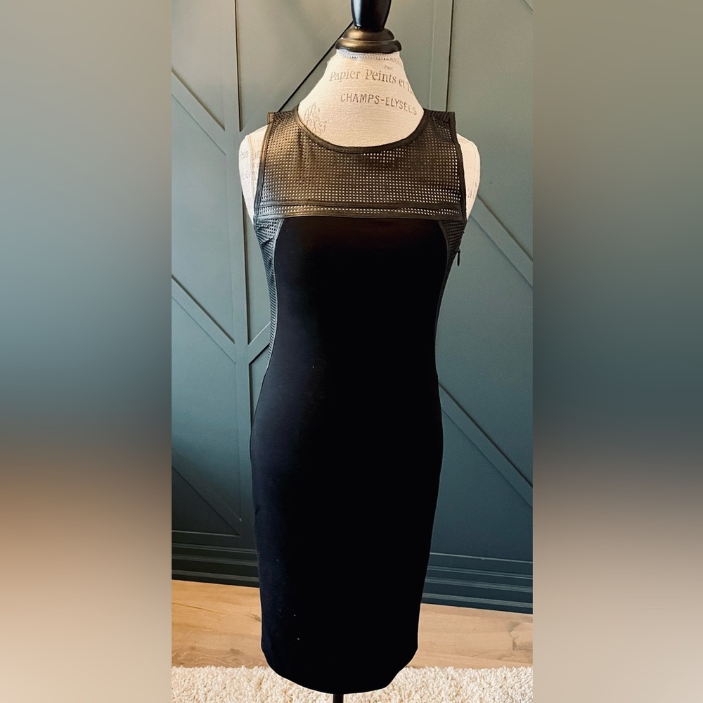 Classy with edge. Black Dress with Leather detailing at the shoulders. Size 4.